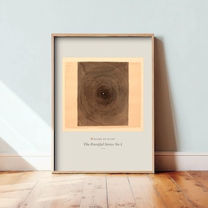 May include: A framed art print featuring a dark brown circular spiral design on a light beige background. Below the central graphic, the text reads: HILMA AF KLINT, The Parsifal Series No 1, 1916. The print is encased in a light wood frame.