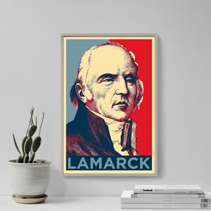 May include: A framed poster featuring a portrait of Jean-Baptiste Lamarck. The artwork uses a color scheme of red, blue, and cream. The name "LAMARCK" is printed in bold, navy blue letters at the bottom of the poster.