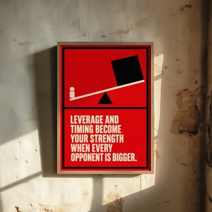 May include: A framed rectangular wall art print with a red background. The top half features a graphic of a seesaw with a small white circle on one side and a large black square on the other. The bottom half displays the text: LEVERAGE AND TIMING BECOME YOUR STRENGTH WHEN EVERY OPPONENT IS BIGGER.