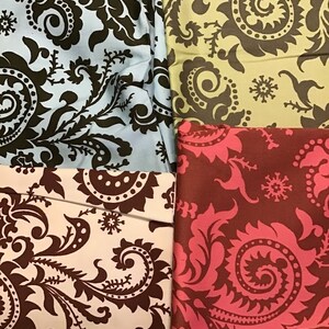 May include: Four fabric swatches with a brown paisley pattern on different colored backgrounds. The swatches are blue, green, white, and pink.