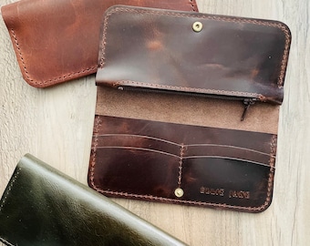 May include: Three leather wallets in different colours: brown, dark brown, and green. The dark brown wallet has the text "Blake Lane" embossed on the front.