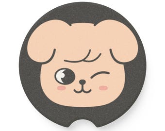 Könnte beinhalten: Ein runder, dunkelgrauer Untersetzer mit einem Cartoon-Hunde-Gesicht. Der Hund hat ein zwinkerndes Auge, Rouge und einen lächelnden Mund. Das Gesicht des Hundes ist hellbraun mit schwarzen und rosa Details. Der Untersetzer hat eine kleine Kerbe unten.