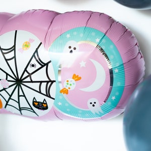 May include: Pink and blue Halloween balloon with a spider web, candy, ghosts, and a crescent moon design.