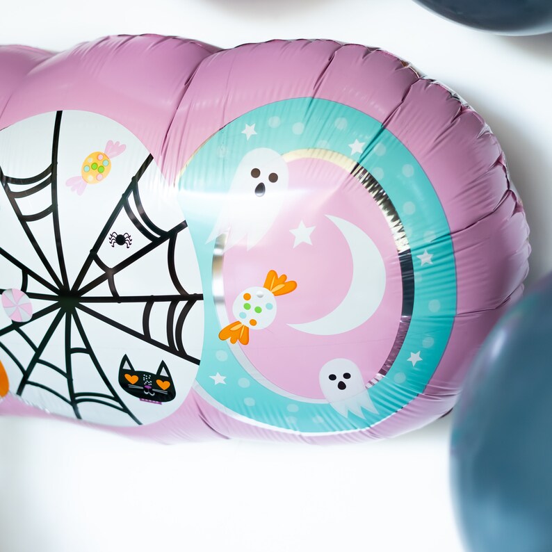 May include: Pink and blue Halloween balloon with a spider web, candy, ghosts, and a crescent moon design.
