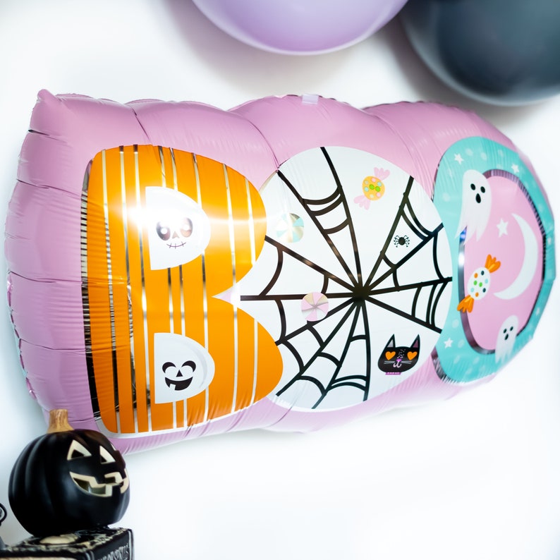 May include: Pink, orange, white, and blue foil balloon shaped like the word "BOO" with a spiderweb, ghosts, and candy designs.
