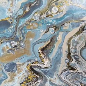 May include: Abstract acrylic painting with fluid art technique. The artwork features a blend of light blue, gold, and neutral tones, creating a marbled effect. The composition includes swirling patterns and organic shapes, evoking a sense of movement and depth.