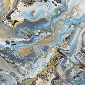 May include: Abstract acrylic pour painting with flowing patterns in shades of blue, gold, gray, and white. The artwork features a marbled effect with organic shapes and textures, creating a dynamic and fluid composition.