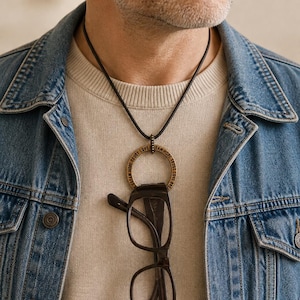 Men's eyeglass holder. Large brass affirmation ring pendant on leather cord.