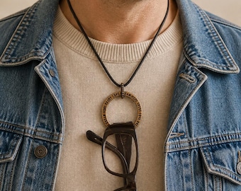 Men's eyeglass holder. Large brass affirmation ring pendant on leather cord.