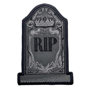 May include: A gray embroidered iron-on patch shaped like a tombstone with the word "RIP" in black lettering.