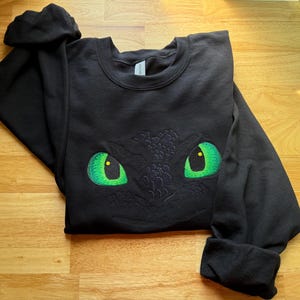 Night Fury Black Dragon Eyes bestickter Kapuzenpullover / Sweatshirt / Hoodie Unisex - Drachenzähmen leicht gemacht