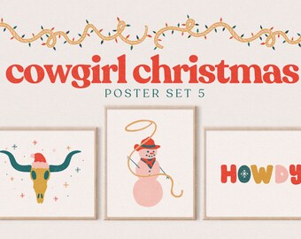May include: Three framed posters with a cowboy Christmas theme. The first poster features a gold cow skull with a red Santa hat. The second poster features a snowman wearing a red cowboy hat and holding a lasso. The third poster features the word "HOWDY" in colorful letters with a snowflake in the "O".