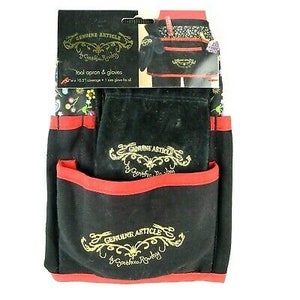 May include: Black gardening apron with multiple pockets and red trim. The apron has a floral print and the text "Genuine Article" in gold embroidery.