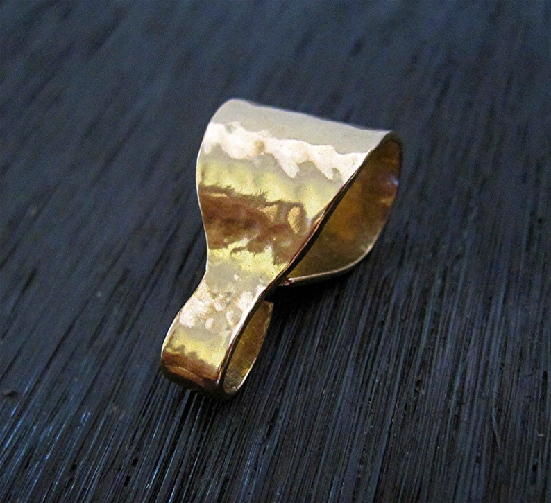 May include: Gold-toned metal pendant bail with a hammered finish. The bail is designed to attach a pendant to a chain or cord.