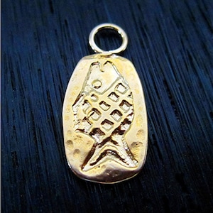 May include: A gold-colored pendant shaped like a fish with a textured surface. The pendant has a loop at the top for attaching to a chain.