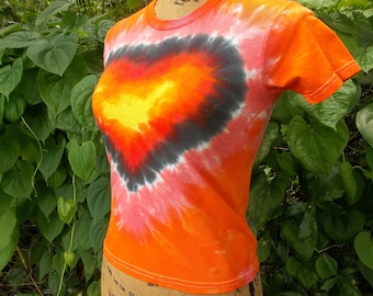 May include: Orange tie-dye t-shirt with a black heart design. The heart is filled with yellow, orange, and red tie-dye.
