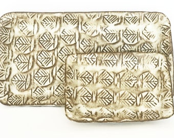 May include: Two rectangular ceramic serving dishes with a white background and a brown leaf pattern.
