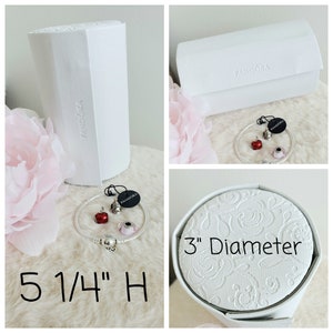 May include: White cylindrical box with the word "Pandora" printed on it. The box is 5 1/4 inches tall. A white round box with the words "3" Diameter" printed on it. A silver bracelet with red and pink charms. The bracelet is in a white box with the word "Pandora" printed on it.