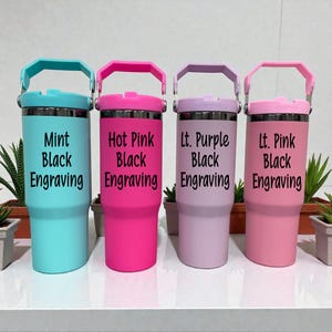 May include: Four insulated tumblers in mint, hot pink, light purple, and light pink. Each tumbler has a matching lid and handle, with black text that reads "Black Engraving". The tumblers are stainless steel.