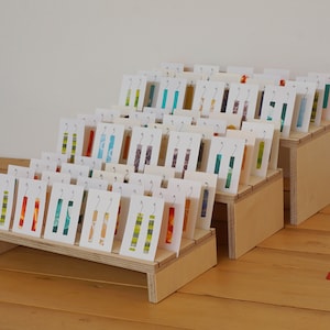 Compact three-shelf nesting display with slots. Versatile portable birch ply jewellery card stand. For shop and market