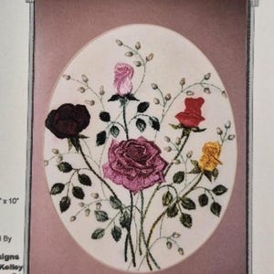 Könnte beinhalten: Ein Stickmuster mit einem Strauß aus fünf Rosen in verschiedenen Farben, darunter rosa, rot, gelb und burgunderrot, mit grünen Blättern und Stielen. Das Design trägt den Titel "Roses, Too" und ist als Design #3807 gekennzeichnet, ein fortgeschrittenes brasilianisches Stickmuster.