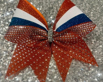 Orange glitter with white and navy Cheerbows with rhinestones.  Attached to non breakable hair tie.