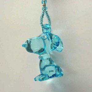 May include: A light blue glass charm of a dog with a black beaded chain.