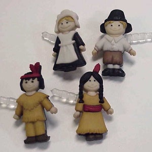 May include: Four small plastic figurines of people dressed in pilgrim and Native American clothing. The figurines are white, brown, and red. They are all wearing different outfits.