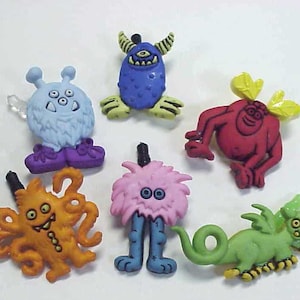 May include: Six colorful plastic monster buttons with various designs, including a blue monster with horns, a red monster with antlers, a pink fuzzy monster, a green monster with wings, a blue monster with three eyes, and an orange monster with tentacles.