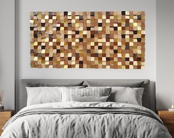 May include: A large, rectangular wooden wall art piece composed of numerous small, square blocks in varying shades of brown, beige, and gold hangs above a bed. The bedroom features a gray bedspread, wooden nightstands, and black pendant lights.