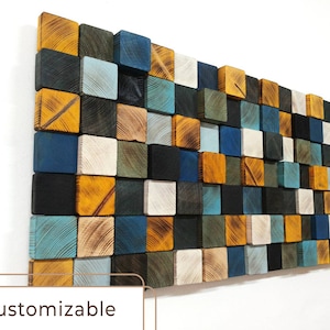 May include: A wall art piece made of wooden squares in various shades of blue, green, yellow, and white. The squares are arranged in a random pattern, creating a modern and abstract design.