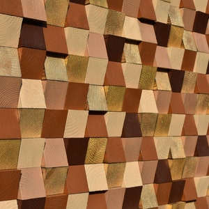 May include: A wall made of wooden blocks in various shades of brown, beige, and gold. The blocks are arranged in a geometric pattern, creating a visually interesting texture.