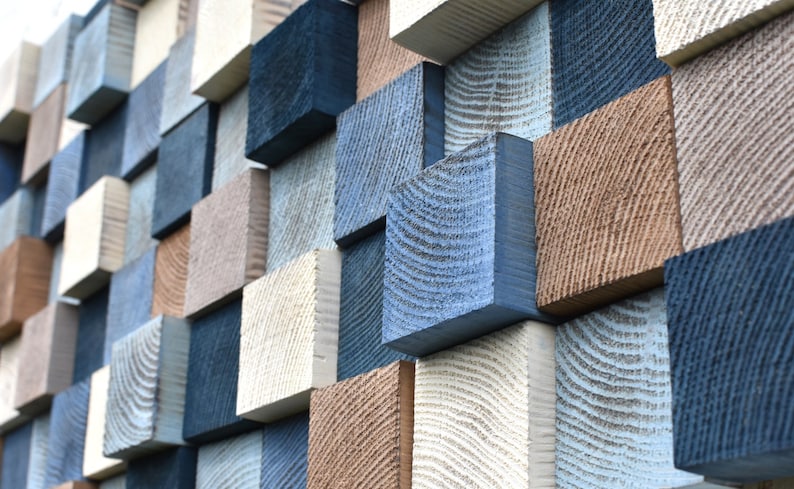 May include: A wall covered in a variety of wooden squares, painted in shades of blue, brown, and white. The squares are arranged in a random pattern, creating a visually interesting and textured surface.