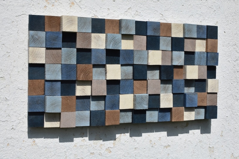 May include: A wall art piece made of wood blocks in various shades of blue, brown, and beige. The blocks are arranged in a grid pattern, creating a modern and abstract design.