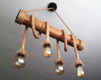 May include: A rustic light fixture made from a bamboo rod with natural rope accents. Four light bulbs hang from the rope, creating a warm and inviting ambiance.