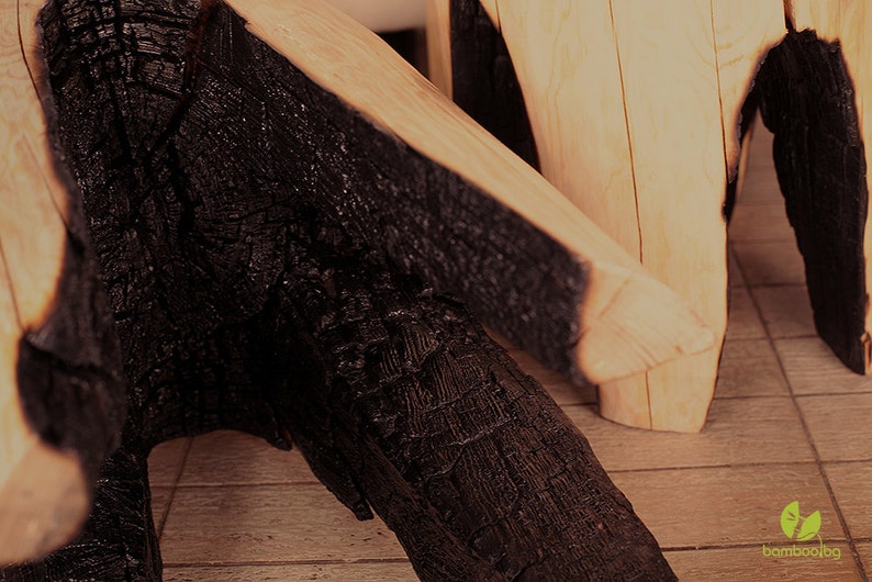May include: Two wooden stools with black charred edges. The stools are made from natural wood and have a rustic, reclaimed look.