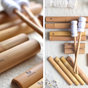 Peut inclure: Un ensemble d'outils de massage en bambou, comprenant des rouleaux, un maillet et une paire de bâtons de massage avec des coussinets en coton blanc. Les outils sont disposés sur une surface blanche avec une serviette blanche en arrière-plan. Les outils sont étiquetés "bamboolag".