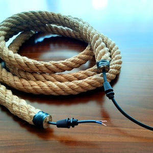 May include: A thick, natural rope cord with black electrical wire and connectors. The rope is coiled and the wire is extended with the connectors at each end.