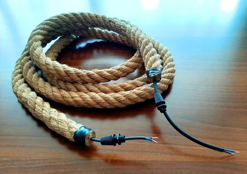 May include: A thick, natural rope cord with black electrical wire and connectors. The rope is coiled and the wire is extended with the connectors at each end.