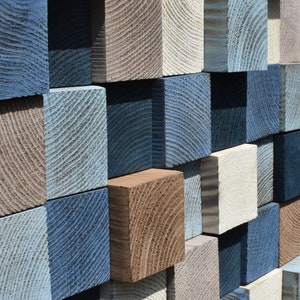 May include: A wall made of various sized wooden blocks, each painted in shades of blue, brown, and white. The blocks are arranged in a staggered pattern, creating a textured and visually interesting surface.