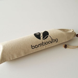 May include: A beige canvas drawstring bag with a black logo that says "bamboo.bg" and a stylized image of a bamboo plant. The bag has a brown drawstring.