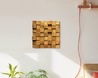Puede incluir: Una pieza de arte de pared hecha de bloques de madera, dispuestos en un patrón de cuadrícula. Los bloques son de color marrón claro y tienen una veta de madera natural.