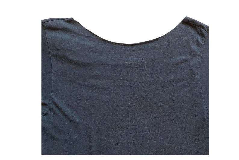 K&ouml;nnte beinhalten: Dunkelblaues T-Shirt mit Rundhalsausschnitt. Der Halsausschnitt ist breit und gebogen, und der Stoff scheint ein weiches, strukturiertes Material zu sein. Die Schultern und der obere R&uuml;cken des T-Shirts sind vor wei&szlig;em Hintergrund sichtbar.