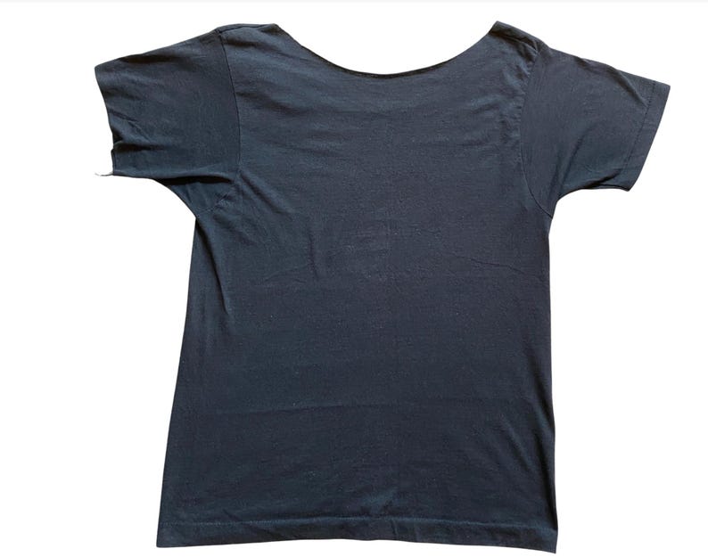 K&ouml;nnte beinhalten: Ein dunkelmarineblaues T-Shirt mit weitem Rundhalsausschnitt. Die kurzen &Auml;rmel sind sichtbar, und das Shirt besteht aus einem weichen, wahrscheinlich Baumwollmaterial. Das Shirt ist vor einem wei&szlig;en Hintergrund fotografiert.
