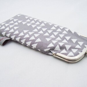 May include: A grey fabric coin purse with a white geometric pattern and a silver clasp.