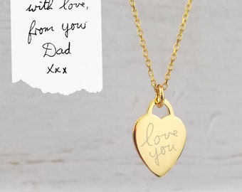 May include: Gold heart necklace with a handwritten inscription that reads "love you". The inscription is engraved on the pendant. The necklace is accompanied by a handwritten note that reads "with love, from you Dad xxx".