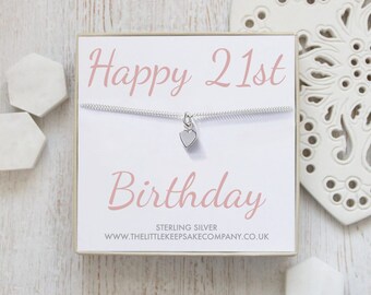 Könnte beinhalten: Eine weiße Geschenkbox mit einer silbernen Halskette darin. Die Halskette hat einen kleinen silbernen Herzanhänger. Die Box trägt den Text "Happy 21st Birthday" in rosa Schrift und den Text "Sterling Silver www.thelittlekeepsakecompany.co.uk" in schwarzer Schrift.