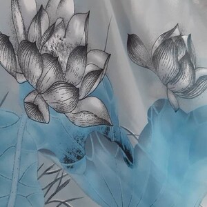 May include: A sheer white curtain with a blue and gray floral pattern. The pattern features lotus flowers and leaves.