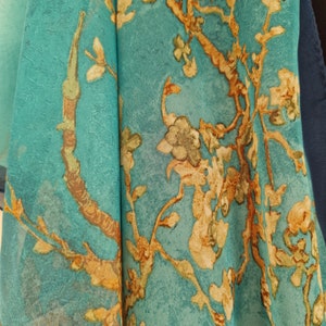 May include: Teal fabric with a floral pattern featuring gold branches and leaves.