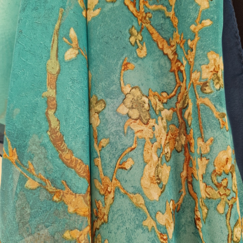 May include: Teal fabric with a floral pattern featuring gold branches and leaves.